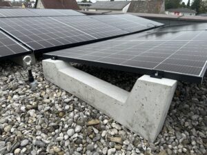 Flat roof photovoltaic array using concrete mounting blocks
