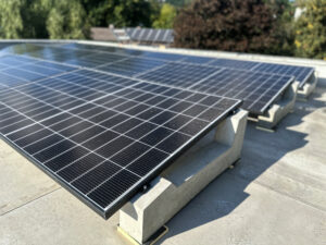 Concrete ballast support for flat roof solar panel mounting